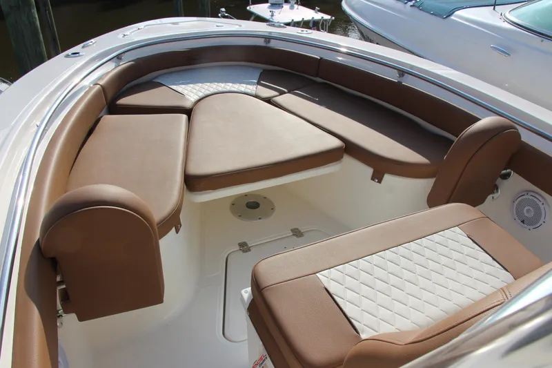 Slide: The Image of 2025 Pioneer 222 Islander boat interior with brown cushioned seating and white accents. - 14