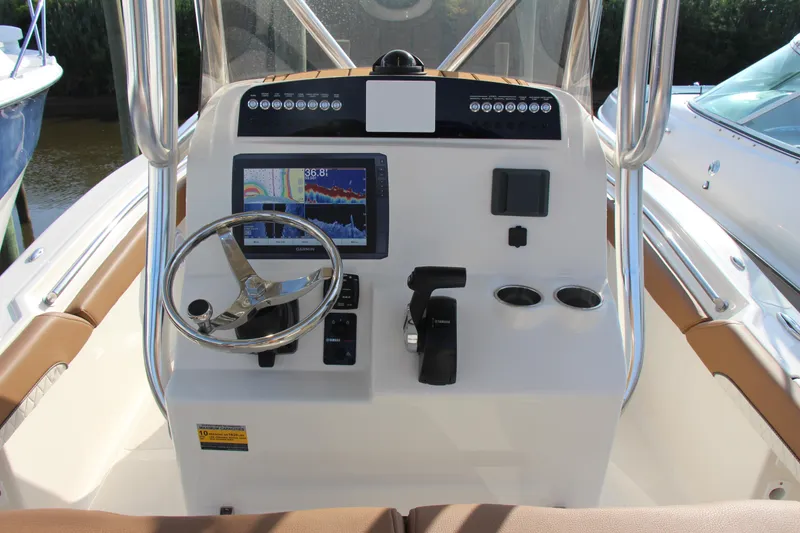 Slide: The Image of 2025 Pioneer 222 Islander boat dashboard with steering wheel and navigation display. - 15