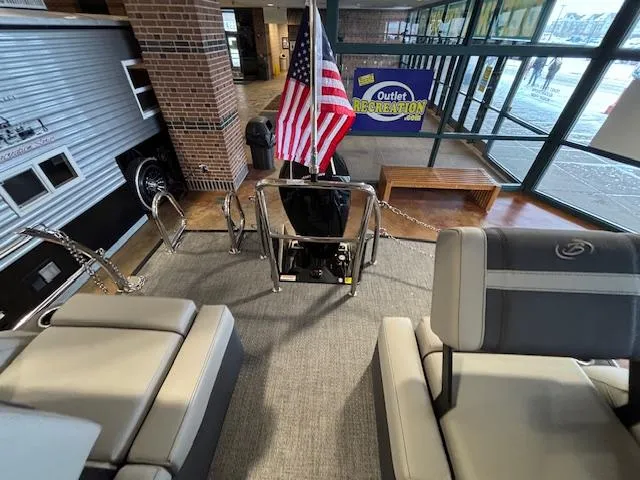 Slide: The Image of 2025 Barletta Cabrio 22M boat interior at showroom with American flag display. - 11