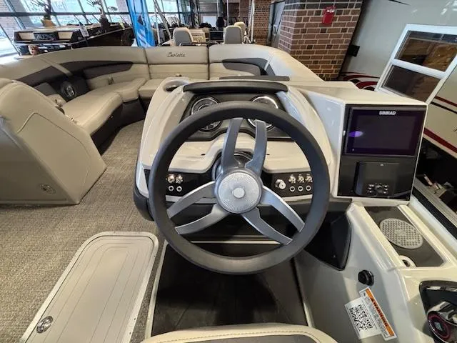 Slide: The Image of 2025 Barletta Cabrio 22M boat interior with steering wheel and seating area. - 22