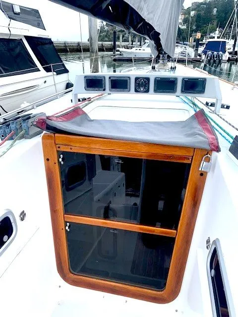 Slide: The Image of 1996 Santa Cruz 52 sailboat cockpit with wooden hatch and marina view. - 10