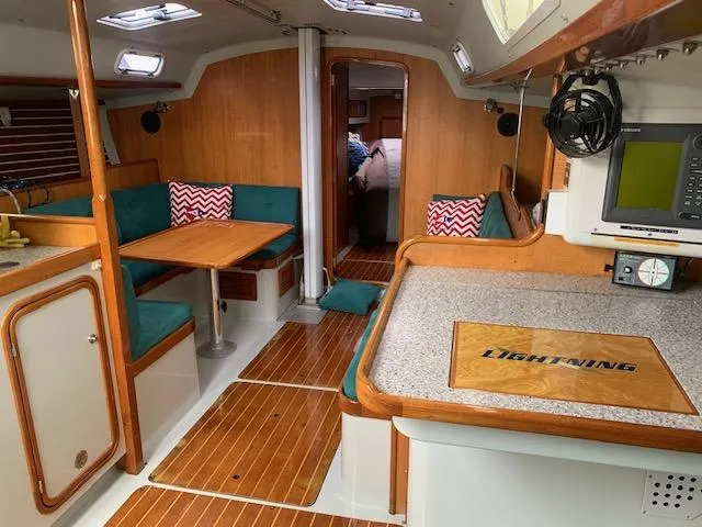 Slide: The Image of Interior of a 1996 Santa Cruz 52 sailboat with wood accents and seating area. - 11