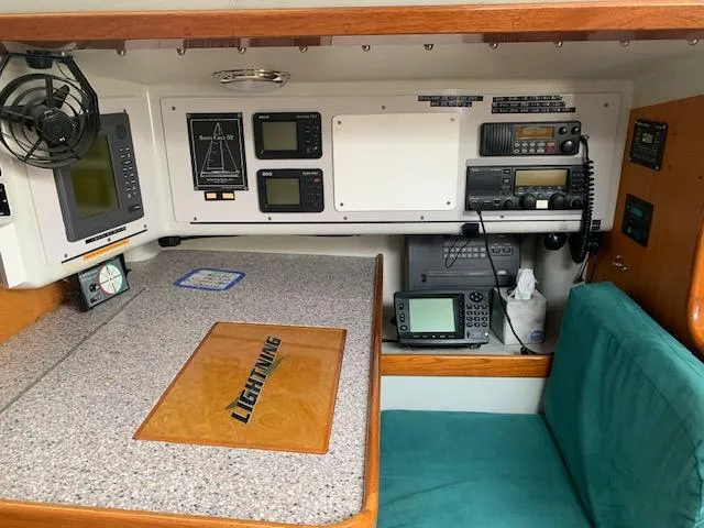 Slide: The Image of Navigation station inside a 1996 Santa Cruz 52 yacht, featuring electronic equipment and seating. - 12
