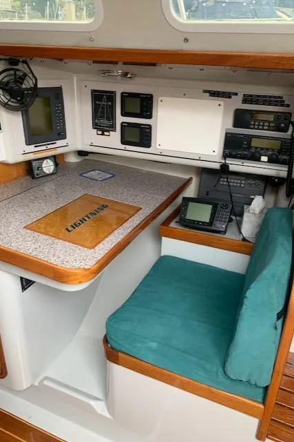 Slide: The Image of Navigation station inside a 1996 Santa Cruz 52 yacht, featuring electronic equipment and a cushioned seat. - 14