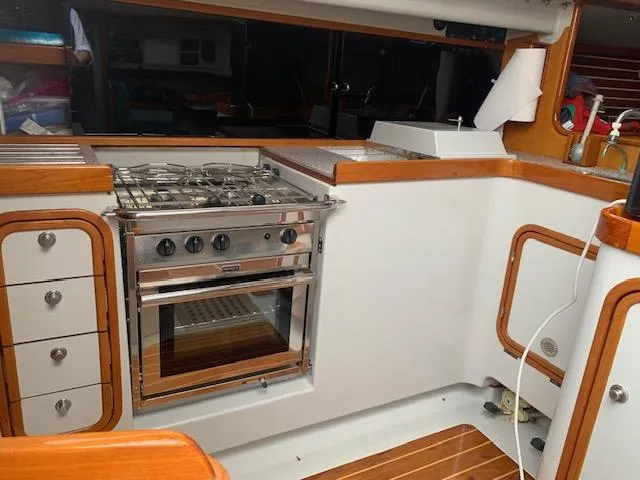 Slide: The Image of Interior of a 1996 Santa Cruz 52 yacht kitchen with stove and wooden cabinetry. - 16