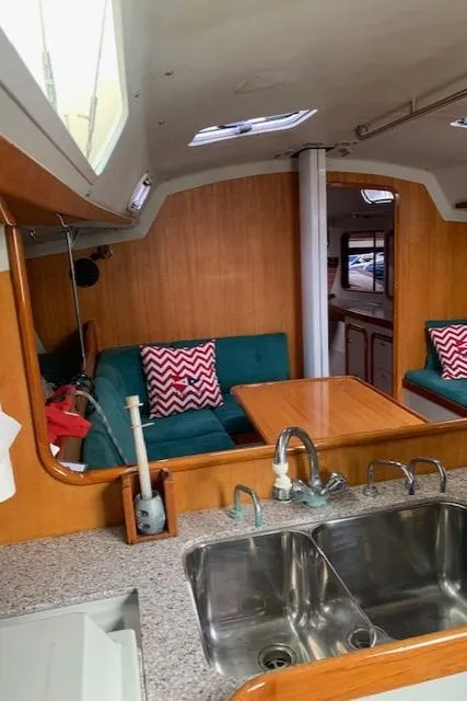 Slide: The Image of Interior of a 1996 Santa Cruz 52 sailboat with a cozy seating area and kitchen sink. - 17