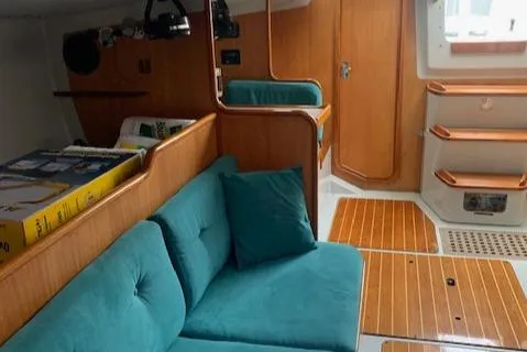 Slide: The Image of Interior of a 1996 Santa Cruz 52 yacht with teal seating and wooden accents. - 20