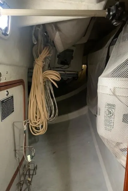 Slide: The Image of Interior of a 1996 Santa Cruz 52 sailboat, featuring storage and coiled ropes. - 23