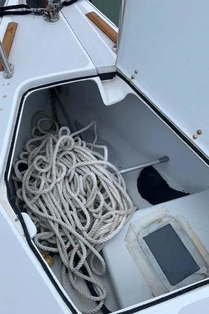 Slide: The Image of Open storage compartment on a 1996 Santa Cruz 52 sailboat with coiled rope inside. - 27