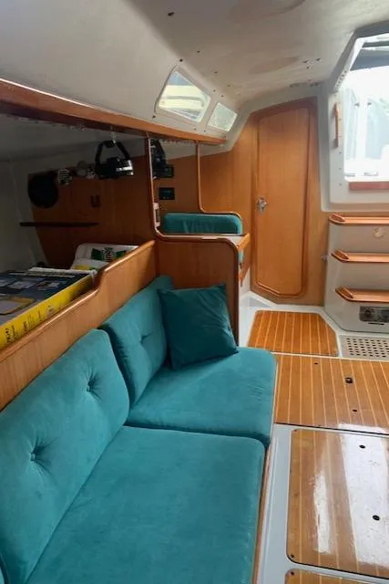 Slide: The Image of Interior of 1996 Santa Cruz 52 yacht with teal seating and wooden accents. - 31