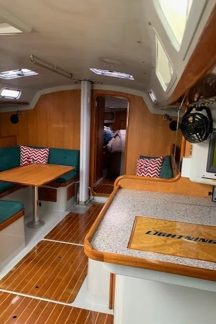 Slide: The Image of Interior of a 1996 Santa Cruz 52 sailboat with wood accents and seating area. - 37