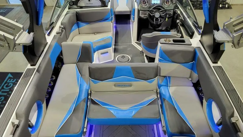 Slide: The Image of 2018 Supra SL 450 boat interior with blue and gray seating, modern dashboard, and ambient lighting. - 10