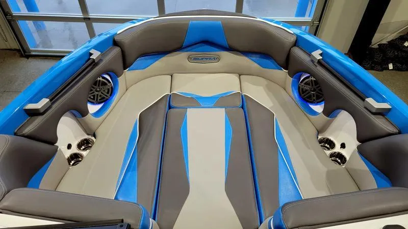 Slide: The Image of 2018 Supra SL 450 boat interior with blue and gray seating, cup holders, and speakers. - 15