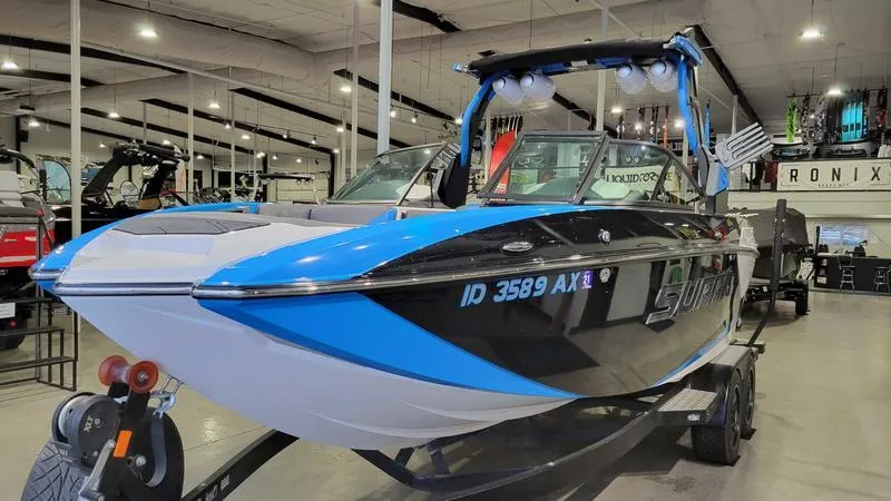 Slide: The Image of 2018 Supra SL 450 boat in showroom, featuring sleek design and vibrant blue accents. - 2