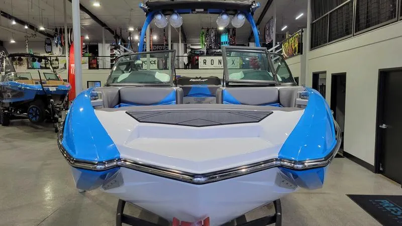 Slide: The Image of 2018 Supra SL 450 boat in showroom, blue and white design, front view. - 4