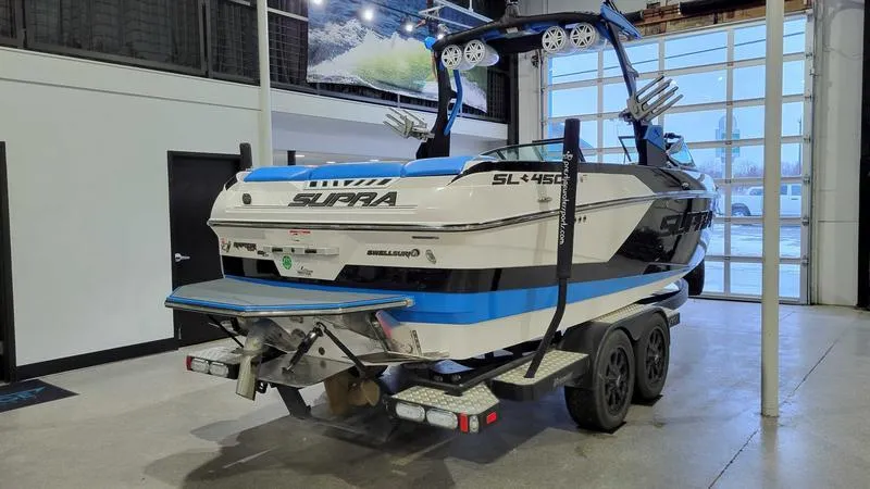 Slide: The Image of 2018 Supra SL 450 boat on trailer in showroom setting. - 5