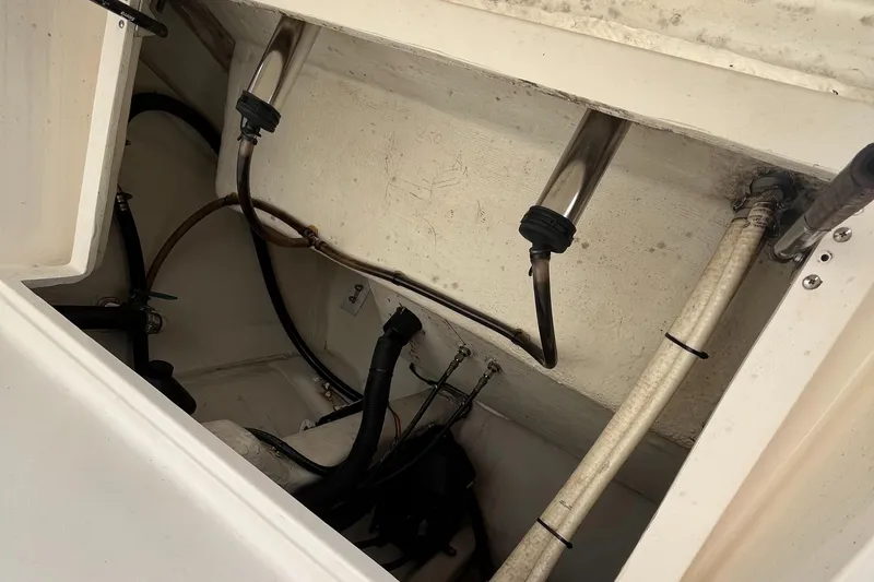 Slide: The Image of Interior view of a 2012 Cobia 237CC boat showing wiring and plumbing components. - 13
