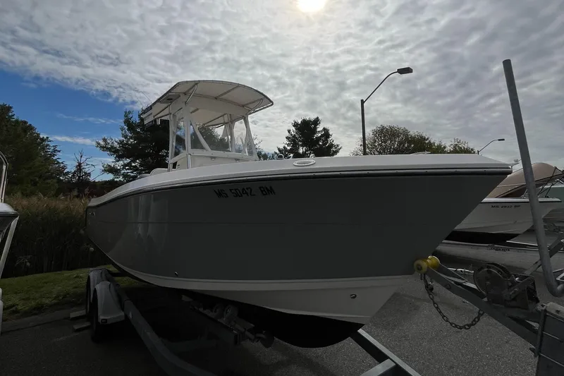 Slide: The Image of 2012 Cobia 237CC boat on trailer under cloudy sky. - 2
