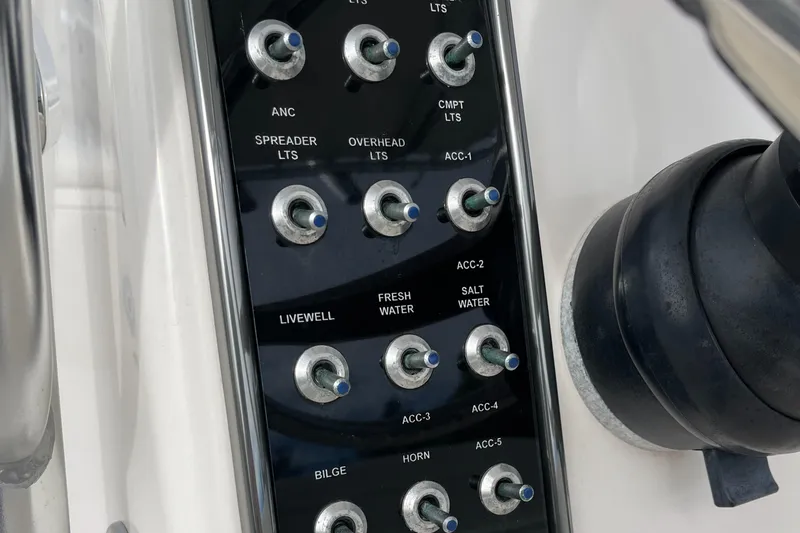 Slide: The Image of Control panel of a 2012 Cobia 237CC boat with labeled switches. - 21