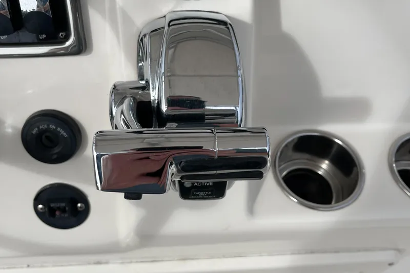Slide: The Image of Chrome boat throttle control on a 2012 Cobia 237CC dashboard. - 25