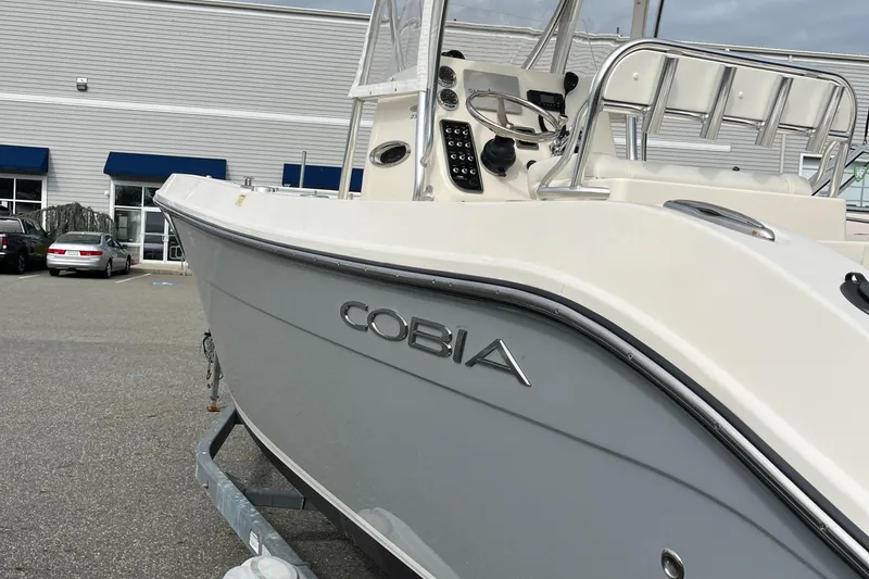 Slide: The Image of 2012 Cobia 237CC boat on trailer, parked outside a building. - 4