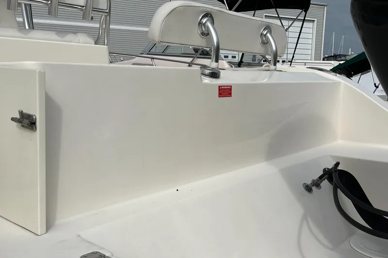 Slide: The Image of 2012 Cobia 237CC boat interior with white seating and stainless steel handles. - 7