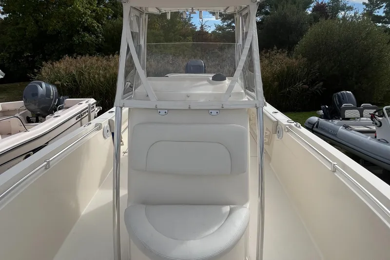 Slide: The Image of 2012 Cobia 237CC boat interior with white seating and clear windshield. - 9