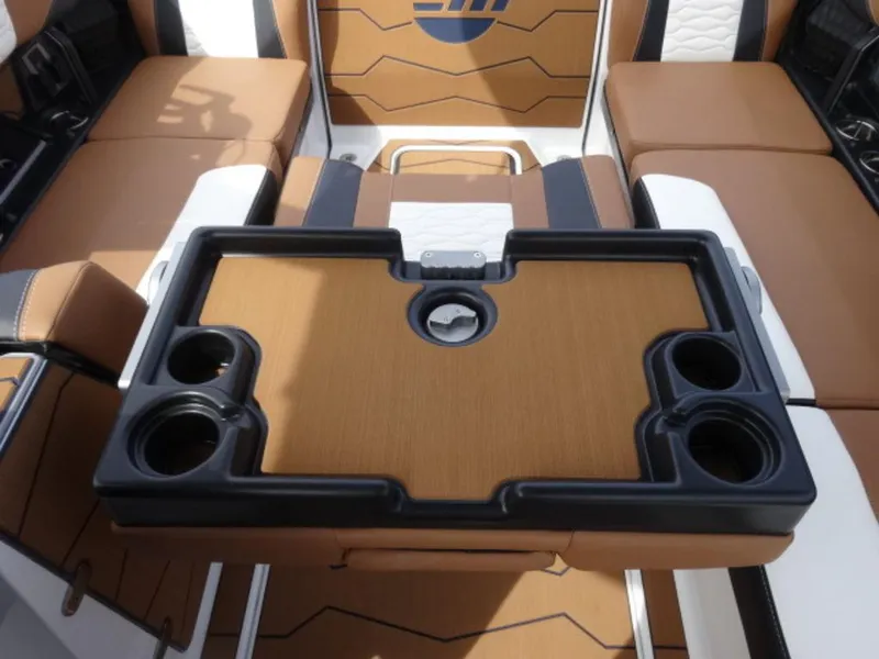 Slide: The Image of 2025 Malibu 24 MXZ boat interior with cup holders and seating area. - 10