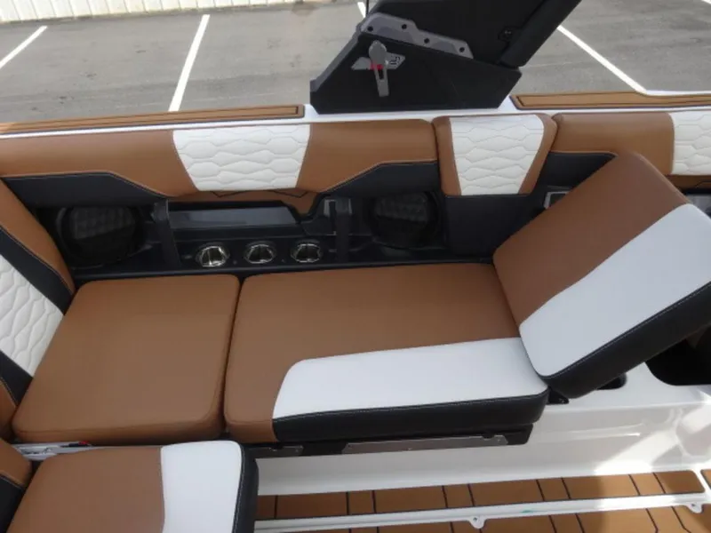 Slide: The Image of 2025 Malibu 24 MXZ boat interior with brown and white cushioned seating. - 12