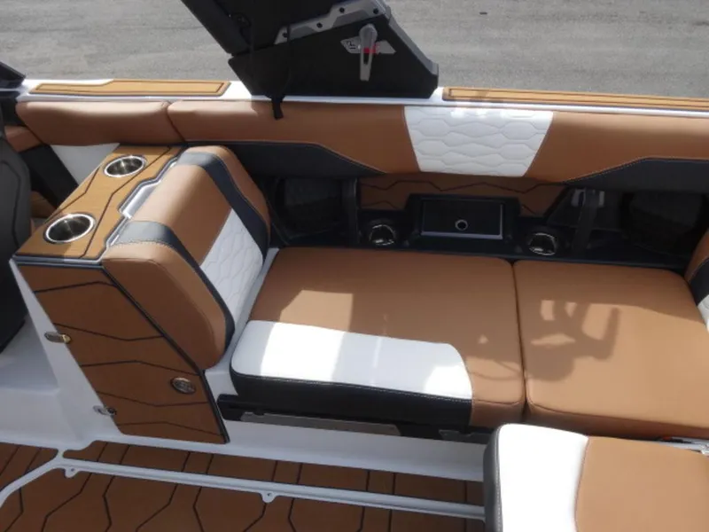 Slide: The Image of 2025 Malibu 24 MXZ interior with tan and white seating, cup holders, and modern design. - 13