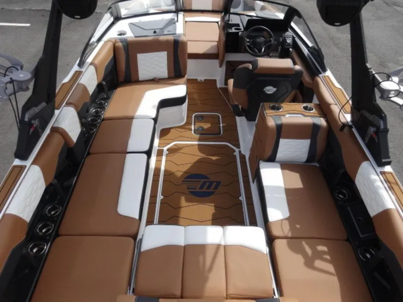 Slide: The Image of 2025 Malibu 24 MXZ boat interior with brown and white seating, modern design. - 4
