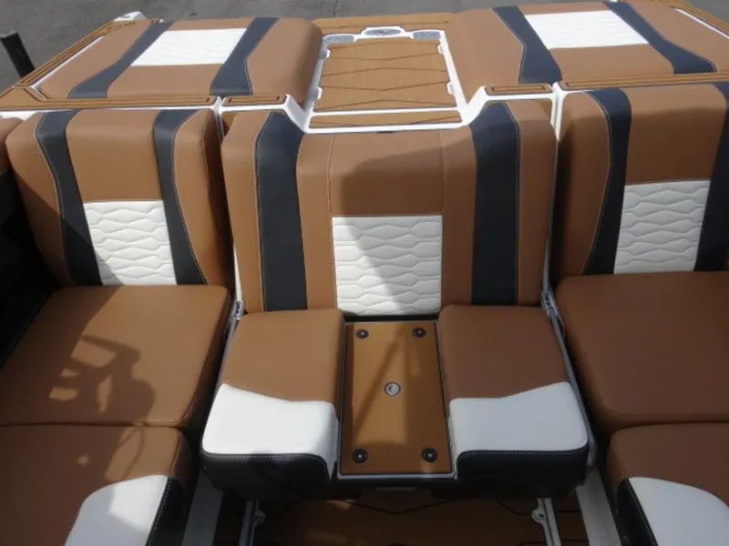 Slide: The Image of 2025 Malibu 24 MXZ boat interior with brown, black, and white seating design. - 6