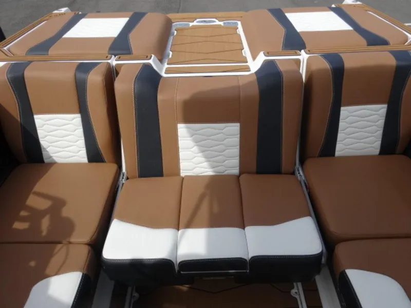 Slide: The Image of 2025 Malibu 24 MXZ boat interior with brown, black, and white seating. - 7