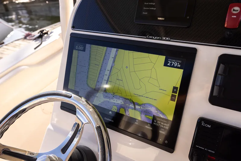 Slide: The Image of 2022 Grady-White 30.6 Canyon boat dashboard with navigation display and steering wheel. - 10