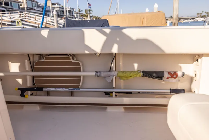 Slide: The Image of Storage compartment on a 2022 Grady-White 30.6 Canyon boat, featuring fishing gear. - 17