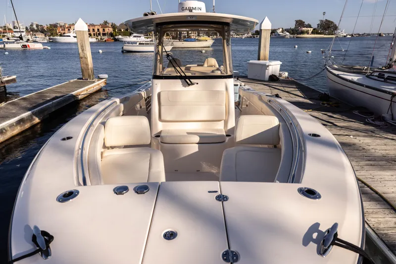 Slide: The Image of 2022 Grady-White 30.6 Canyon boat docked at marina, showcasing spacious seating and sleek design. - 4