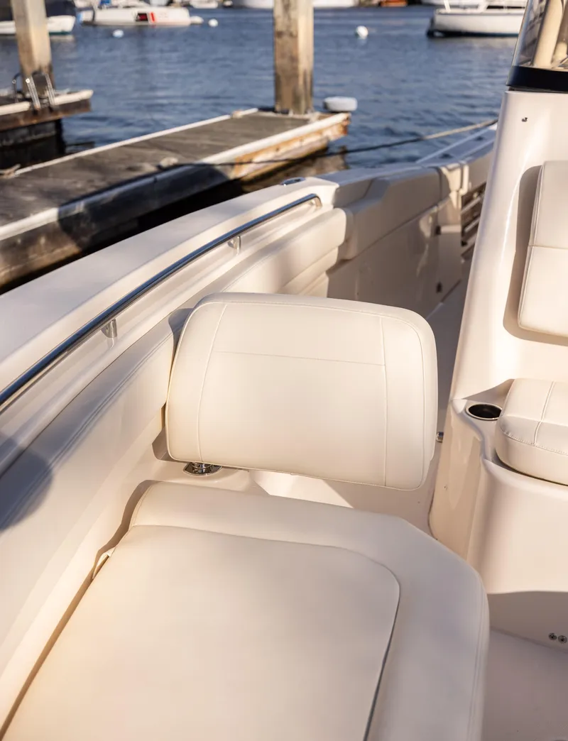 Slide: The Image of 2022 Grady-White 30.6 Canyon boat interior with white seating by the dock. - 6