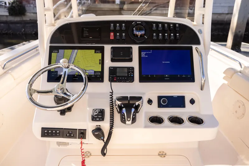 Slide: The Image of 2022 Grady-White 30.6 Canyon boat dashboard with navigation and control systems. - 9