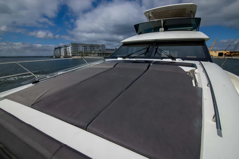 Slide: The Image of 2018 Prestige 680 Flybridge yacht with spacious deck, docked near waterfront buildings. - 44