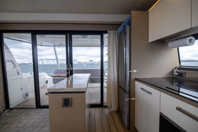 Slide: The Image of Interior of 2018 Prestige 680 Flybridge yacht with modern kitchen and ocean view. - 8