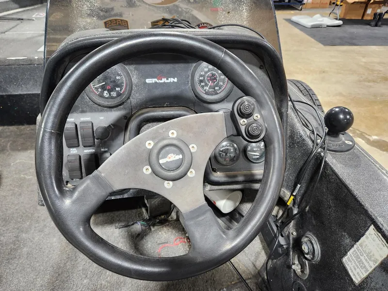 Slide: The Image of Steering wheel and dashboard of a 1996 Cajun Master boat. - 13