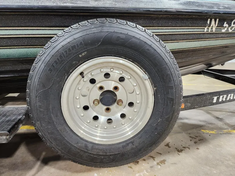 Slide: The Image of Trailer wheel of a 1996 Cajun Master boat, featuring a sturdy tire and rim. - 14