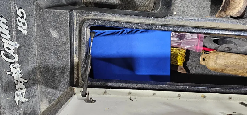 Slide: The Image of Storage compartment in a 1996 Cajun Master boat with various items inside. - 24
