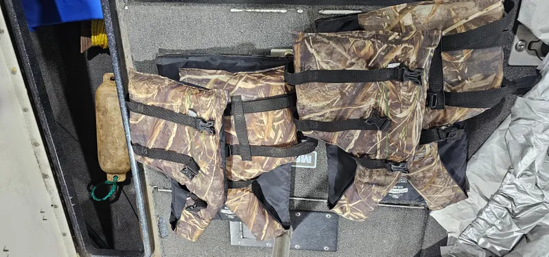 Slide: The Image of Camouflage life jackets on a Cajun Master 1996 boat interior. - 25