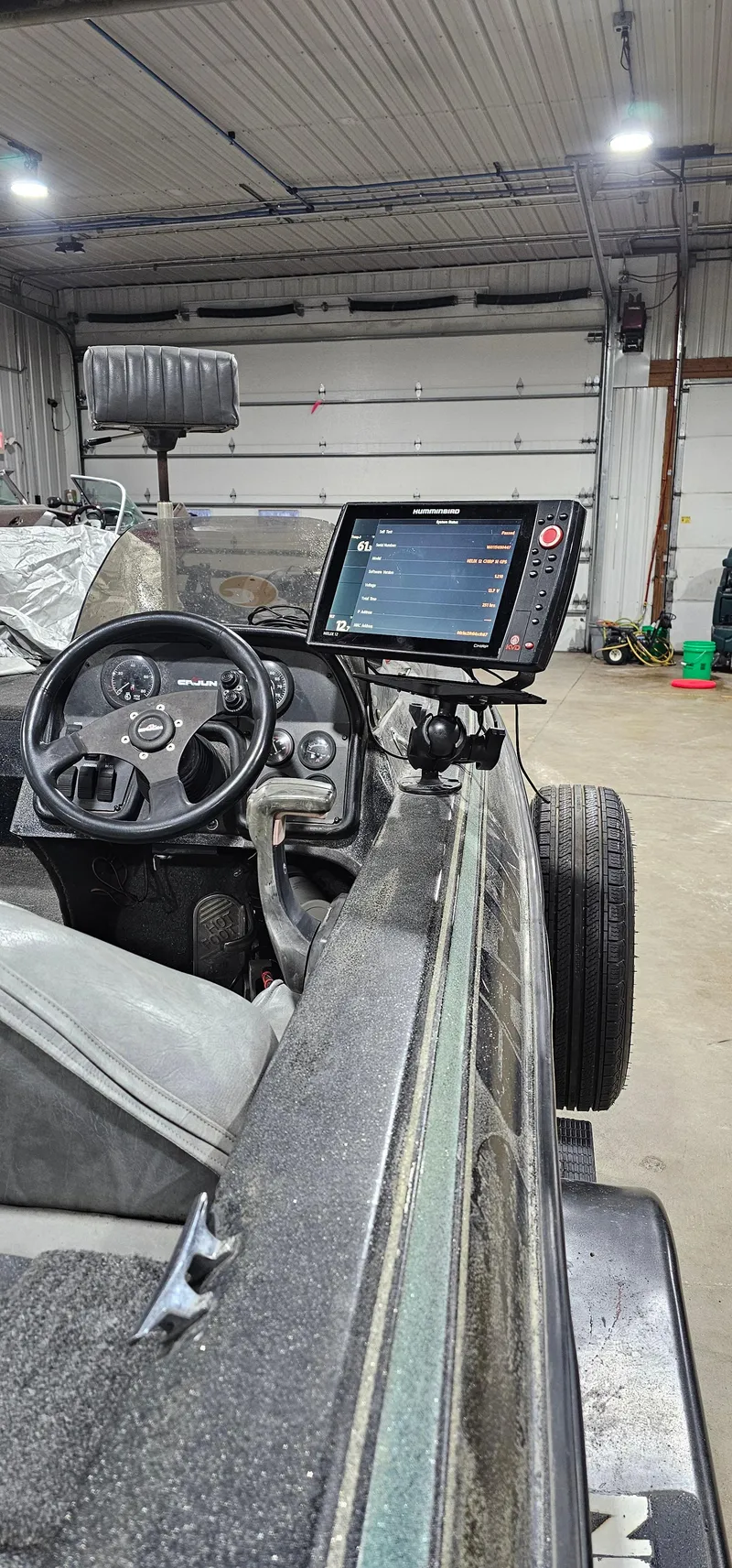 Slide: The Image of 1996 Cajun Master boat interior with steering wheel and mounted navigation screen. - 28