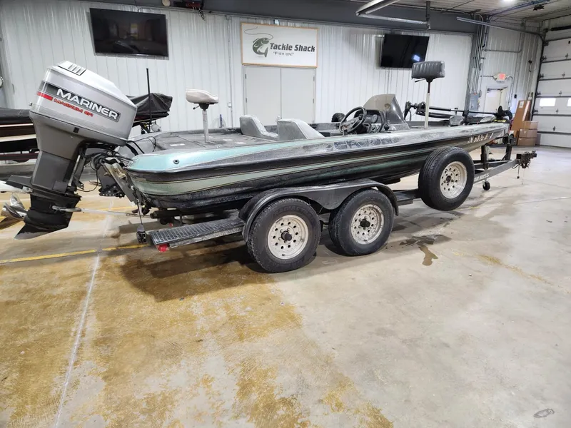 Slide: The Image of 1996 Cajun Master boat with Mariner outboard motor in a garage setting. - 3