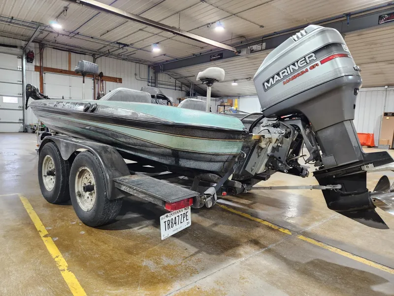 Slide: The Image of 1996 Cajun Master boat with Mariner outboard motor in a garage setting. - 5