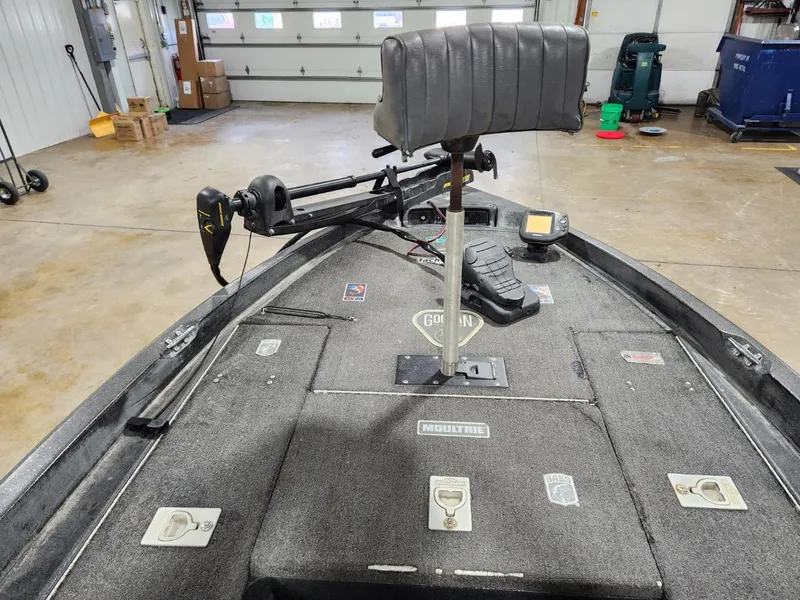 Slide: The Image of 1996 Cajun Master boat interior with trolling motor in a garage setting. - 7