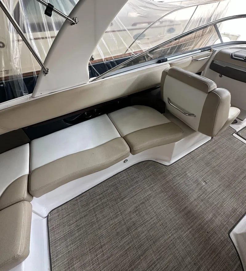 Slide: The Image of 2012 Regal 2700 Bowrider interior with beige seating and carpeted flooring. - 10