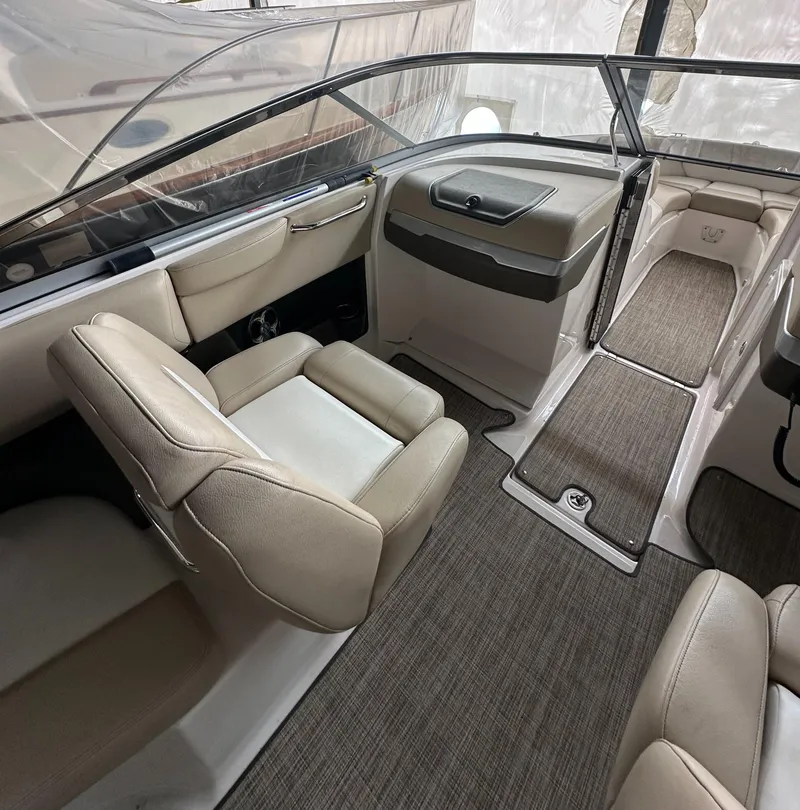 Slide: The Image of 2012 Regal 2700 Bowrider interior with beige seating and carpeted flooring. - 12